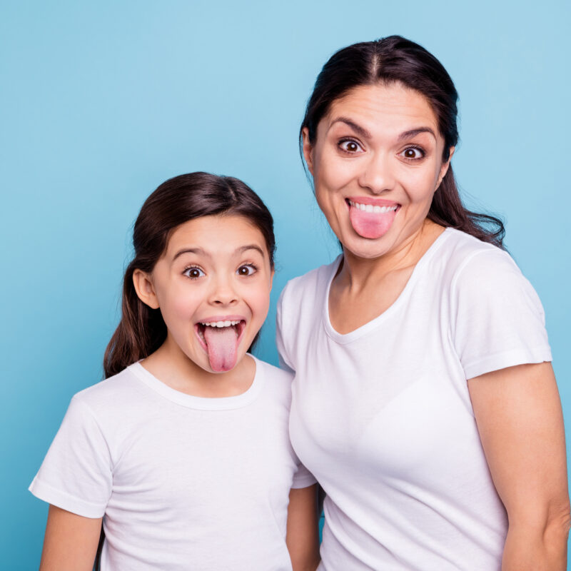 Mom and daughter sticking their tongues out