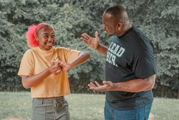 a father talks to his daughter in a field