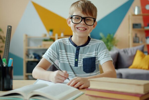 boy smiling at desk in school