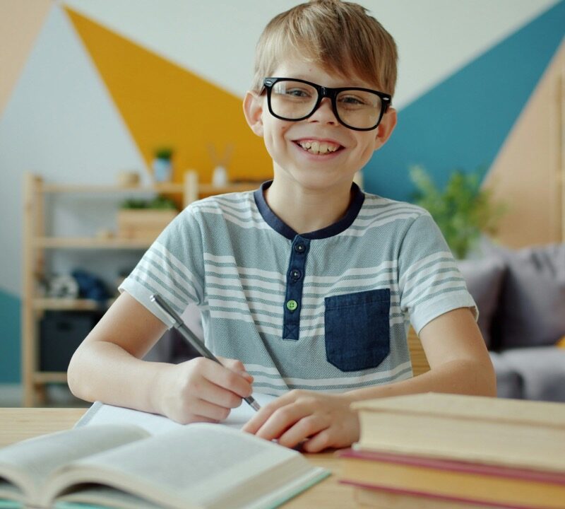 boy smiling at desk in school